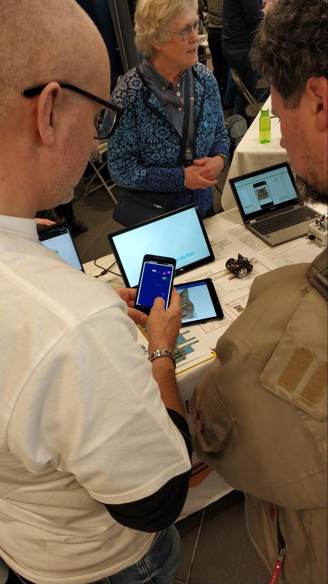 Power Users Peter and Ghica demonstrates an app to a passerby